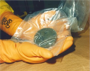 A technician holds a sample of plutonium. Only a small amount of plutonium (8 kg or less) is required for a basic nuclear bomb.  